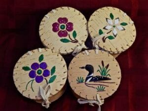 A set of four wooden coasters with flowers and ducks.