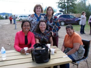 A group of women sitting at a picnic table.