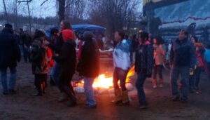 A group of people standing around a fire.